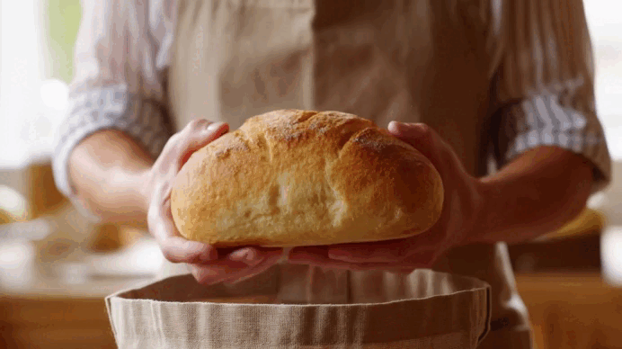 Hands holding a freshly baked loaf